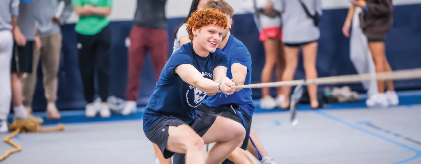 Students playing tug of war indoors.